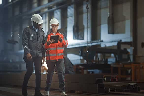 construction workers looking over a project plan while on a busy worksite